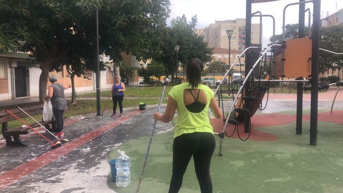 Vecinas de Carretera de Cádiz, este jueves, limpiando un parque infantil público.