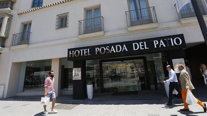 Varias personas pasan junto a uno de los dos hoteles de cinco estrellas de Málaga capital.