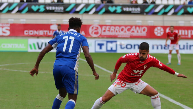 El jugador del Marbella Mustafa encara a un rival durante el partido en La Condomina.