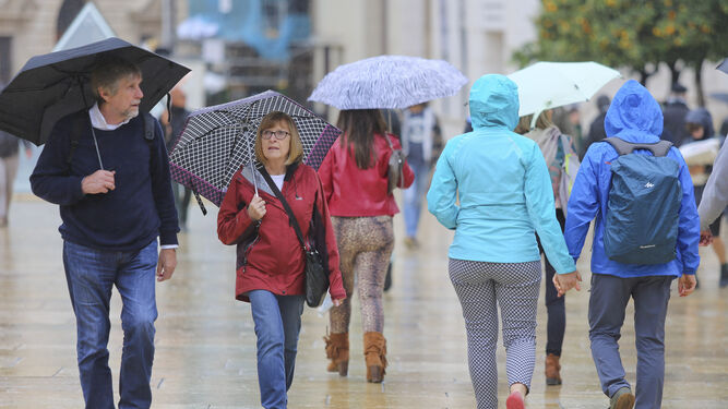 Varias personas con paraguas por las lluvias en Málaga.