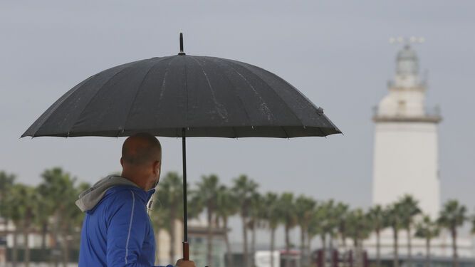 Un hombre se resguarda de la lluvia en el último temporal en Málaga.