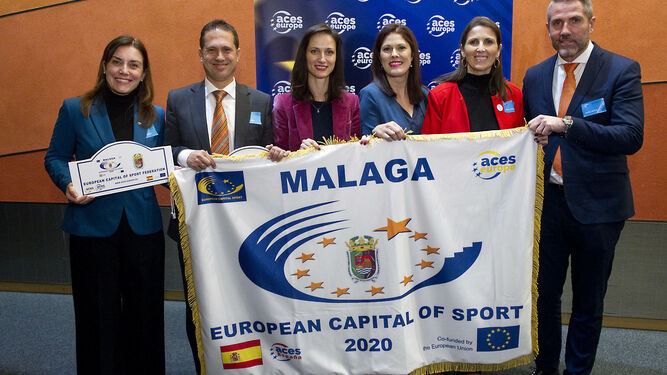 La representación malagueña recibe la bandera de Málaga 2020.