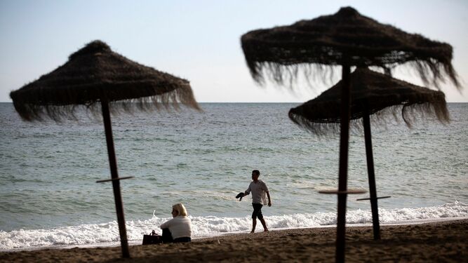 Varias personas disfrutan del buen tiempo en la playa de La Malagueta.