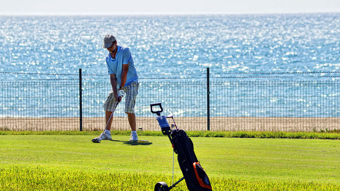 Un hombre practicando al golf.