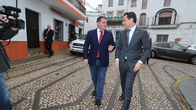 El alcalde de Jabugo, Gilberto Domínguez, recibe al presidente de la Junta de Andalucía, Juanma Moreno, a las puertas del Ayuntamiento.