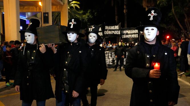 Los aficionados, completo de negro, portan un ataúd que simboliza el "cadáver" del club.