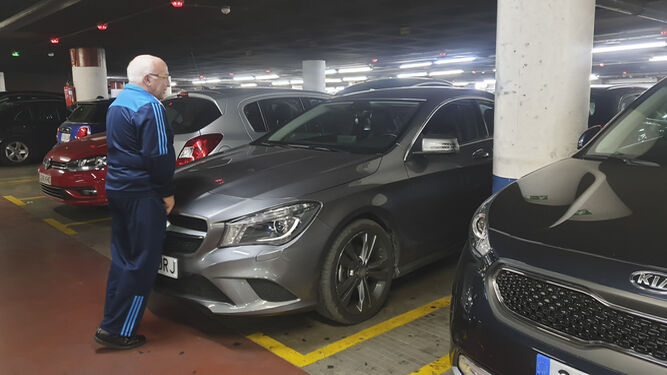 Un usuario del parking de La Marina empuja su vehículo para poder estacionar.