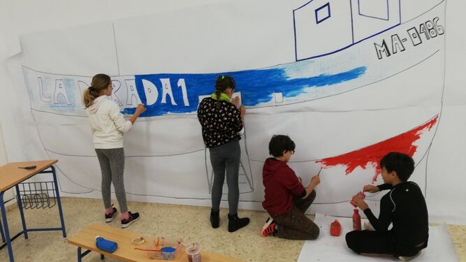 Alumnos del CEIP Nuestra Señora del Carmen pintan el barco de Chanquete.