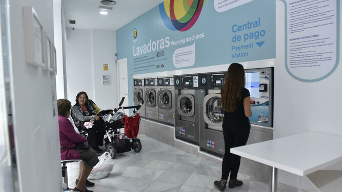 Tres mujeres esperan en una lavandería de Sevilla.