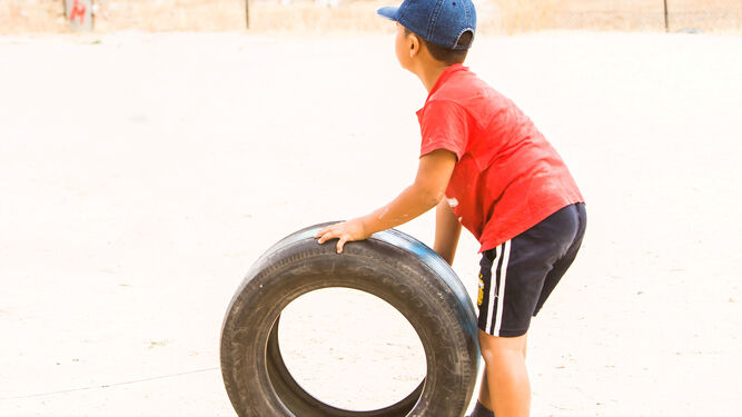 Un niño juega con una rueda.