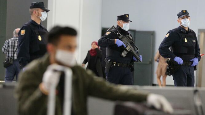 Policías nacionales con mascarillas en el aeropuerto de Málaga