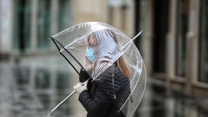 Una mujer protegiéndose de la lluvia, durante el estado de alarma.