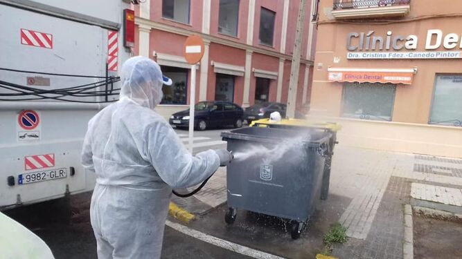 Un operario desinfecta un contenedor de basura en Los Palacios.