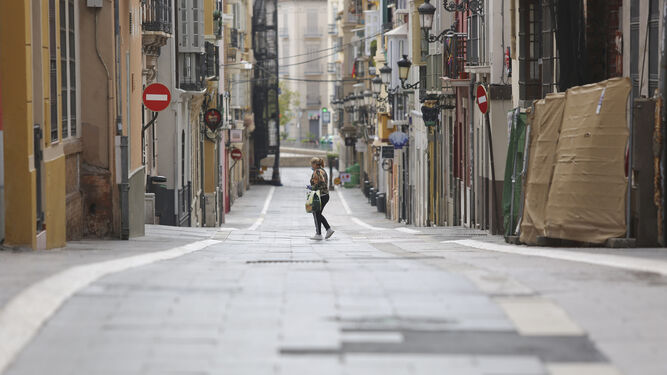 Una mujer camina sola por la calle Madre de Dios durante la epidemia.