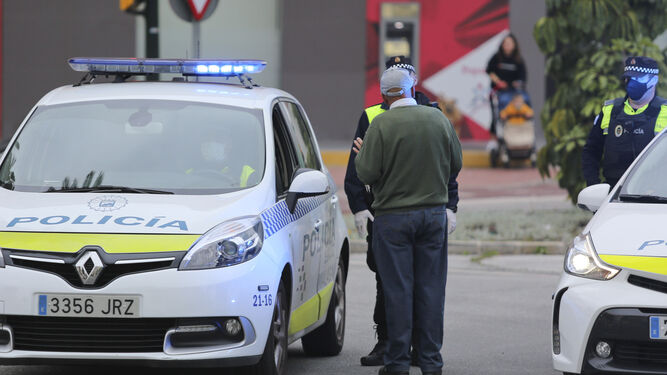 Dos agentes de la Policía Local de Málaga identifican a un vecino.