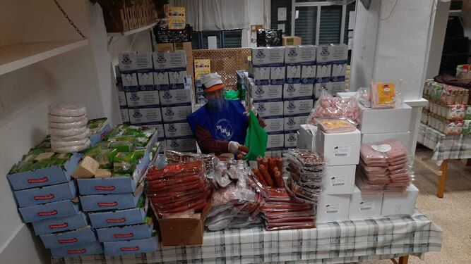 Un voluntario elabora lotes de productos para la entrega del comedor Yo soy Tú.