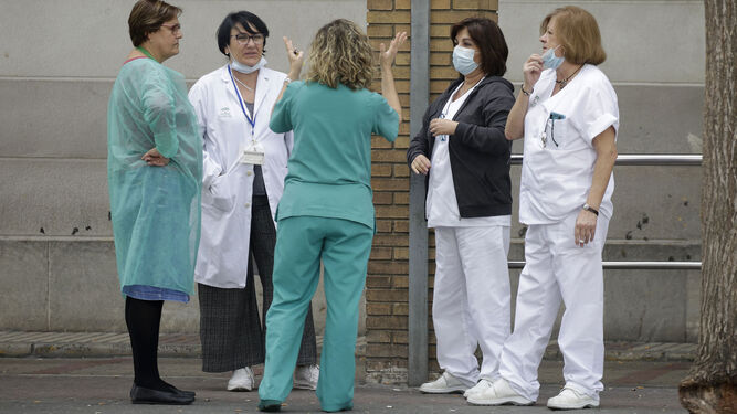 Un grupo de sanitarios conversa en el exterior de un hospital.