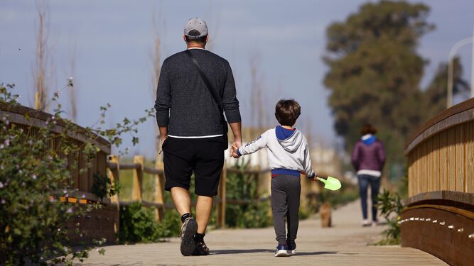 Un niño pasea junto a su padre en Málaga.