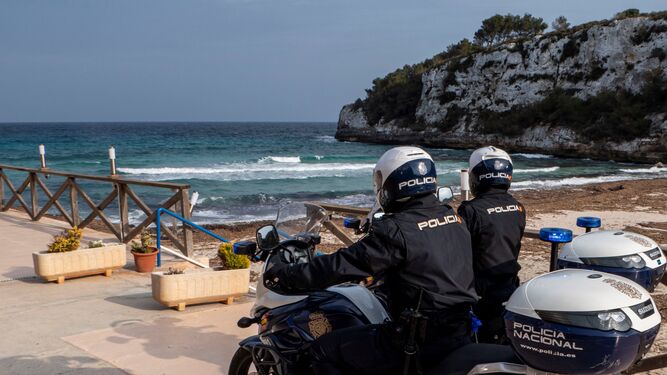 Dos policías patrullan una playa española dos semanas atrás.