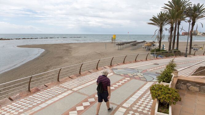 Un hombre pasea por el paseo de la playa de Benalmádena.