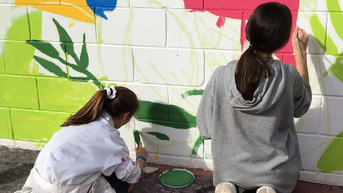 Dos niñas pintan un mural en una de las actividades de Espacio de Dentro.