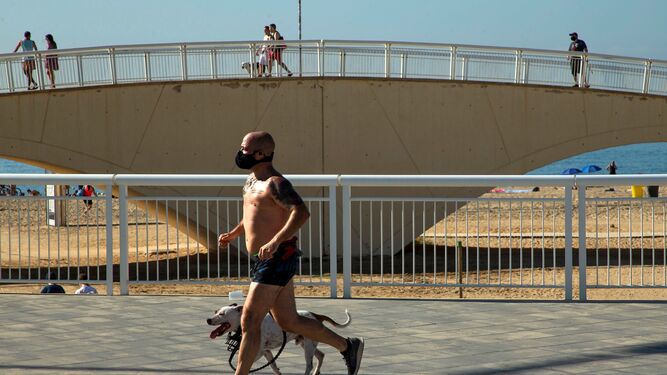 Un hombre hace deporte en Barcelona con mascarilla.