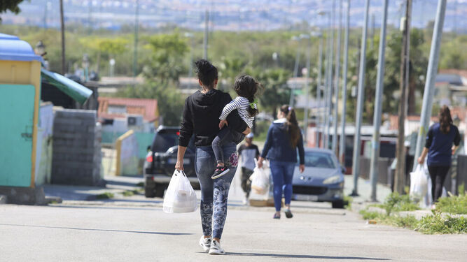 Una mujer con su hija, a la salida de un reparto de alimentos en Málaga.