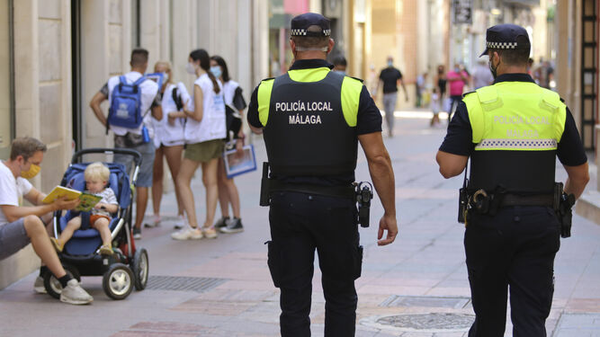 Dos agentes de la Policía Local de Málaga patrullan por el Centro.