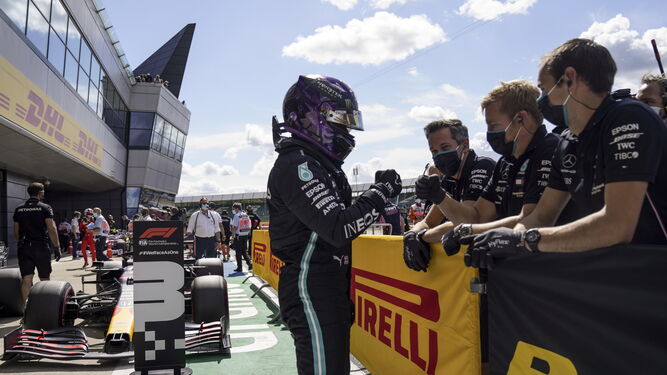 Hamilton celebra la 'pole' en boxes con  sus compañeros de equipo.