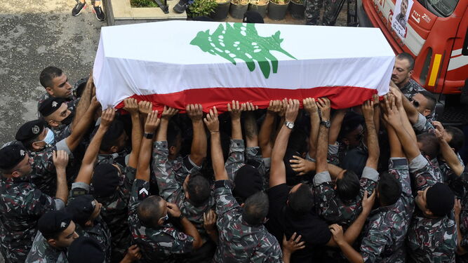 Un grupo de bomberos portan el féretro de un compañero ayer en Beirut.