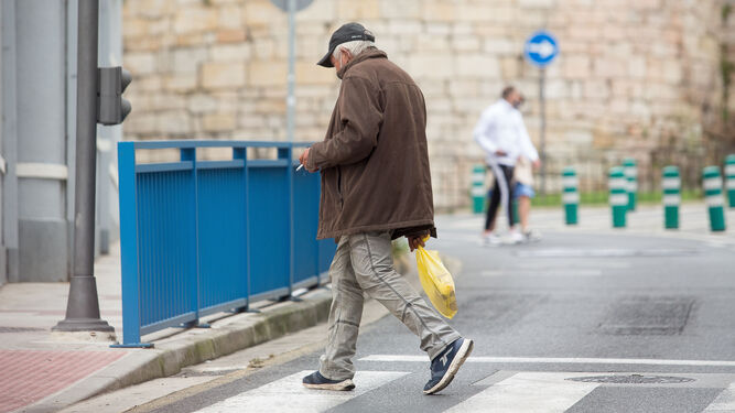 Una persona fuma por la calle en el primer día de restricciones en Galicia.