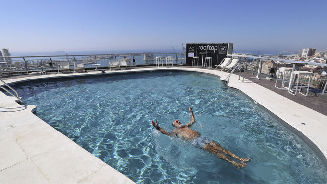 Un turista se baña solo en la piscina de un hotel en Málaga este verano.