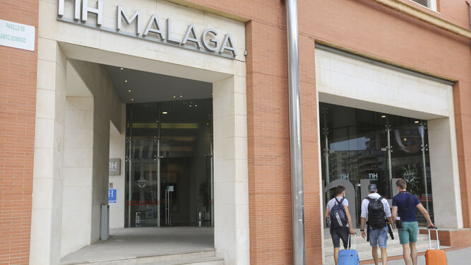 Tres turistas en la puerta del hotel NH en Málaga capital.
