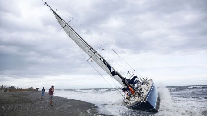 Fotos del velero encallado en la playa de Benajarafe, tras quedar a la deriva por el viento