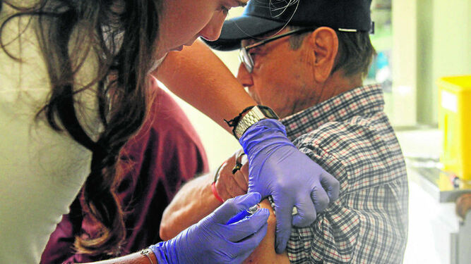 Una sanitaria pone la vacuna de la gripe a un hombre en una campaña anterior.