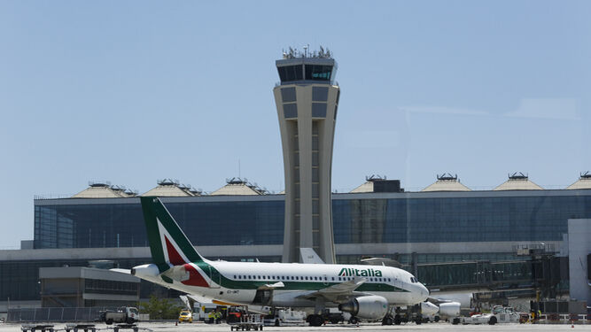 Un avión junto a la torre de control del aeropuerto de Málaga.