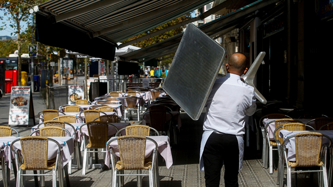 Un camarero retira una mesa de un restaurante.