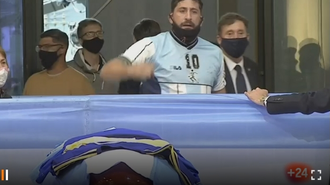 Un aficionado pasa ante el féretro de Maradona en la capilla ardiente