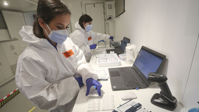 Dos técnicas realizan pruebas en una de las unidades móviles de la Junta presentada el viernes en Málaga.