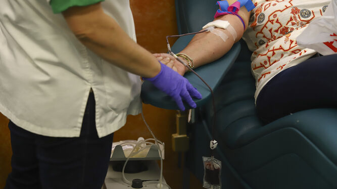 Una mujer donando sangre.