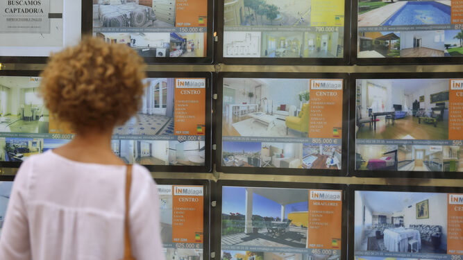 Una mujer observa el escaparate de una inmobiliaria en Málaga.