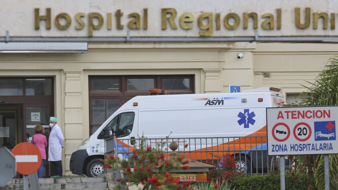 Una ambulancia y sanitarios en la puerta del Hospital Regional de Málaga.