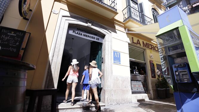 Varios turistas entran a un edificio de apartamentos turísticos de Málaga capital.