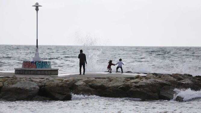 Dos niños jugando con las olas este sábado.