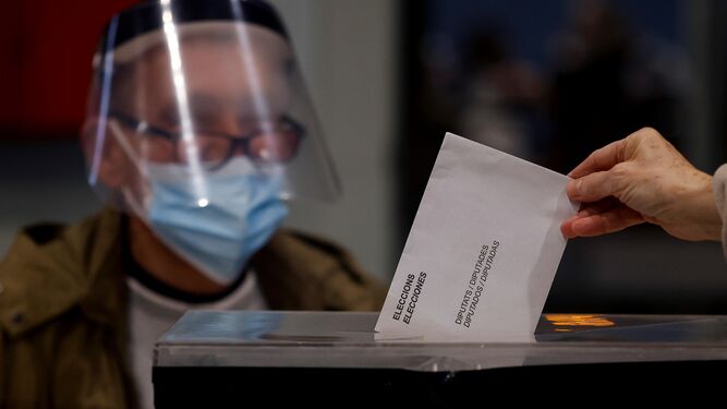 Una persona deposita su voto en el polideportivo Can Ricart del barrio del Raval de Barcelona