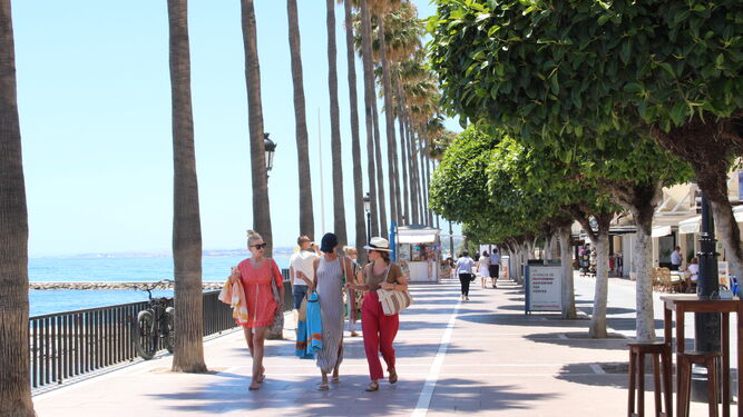 Unas turistas caminando por el paseo marítimo de Marbella.