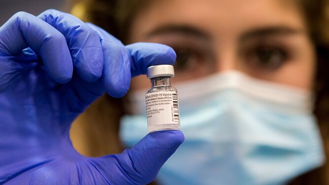 Una enfermera muestra el vial con varias dosis de vacuna.