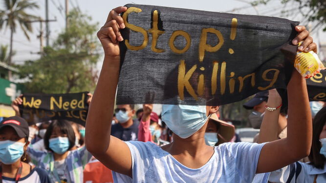 Una manifestante porta una pancarta pidiendo el fin de los asesinatos