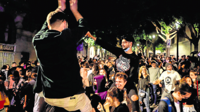 Decenas de jóvenes celebran junto al Passeig de Lluis Companys de Barcelona, el fin del estado de alarma.
