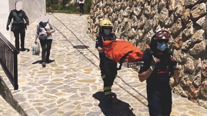 Efectivos del Consorcio Provincial de Bomberos trasladan a la mujer herida en Árchez.